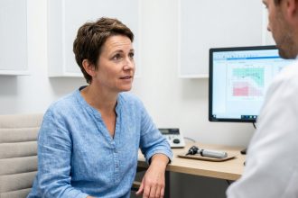 Femme consultant un audiologiste dans un cabinet médical moderne, examen auditif précoce