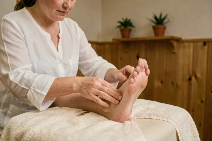 Thérapeute pratiquant la réflexologie plantaire sur le pied d'une cliente dans un studio de bien-être